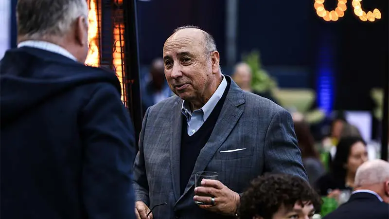 A man holding a glass talking to someone